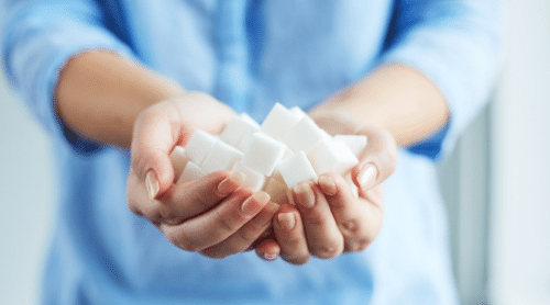 woman holding out sugar cubes featured