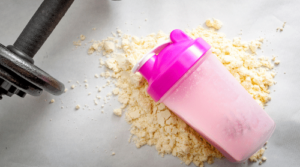 protein powder, pink shaker bottle, and dumbbell featured