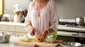 older woman chopping vegetables in kitchen featured