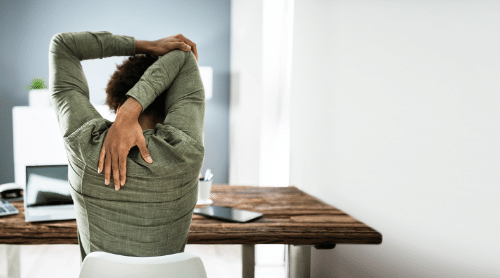 woman doing yoga stretch at her desk featured