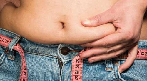 woman with bloated belly in jeans with tape measure featured