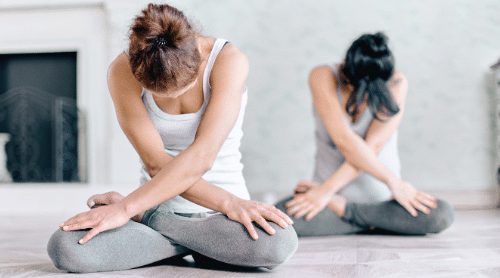 women doing relaxing yoga pose featured