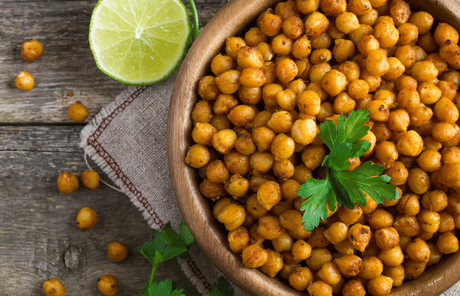 chickpeas in a bowl with a lime and green herbs