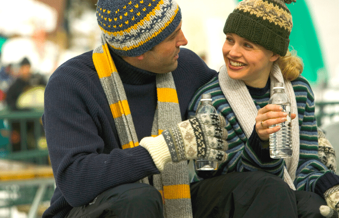 man and woman in winter clothes drinking water