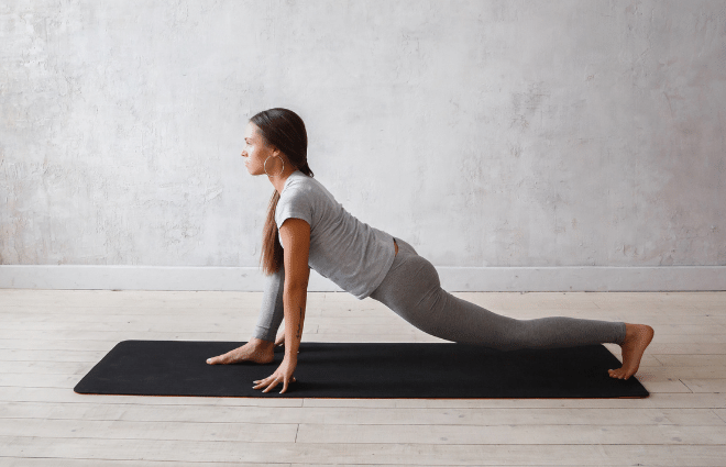 woman doing yoga lunge with hands on mat near feet, back knee down