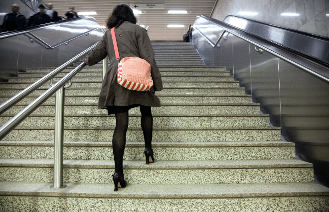 woman taking the stairs instead of the escalator for more exercise