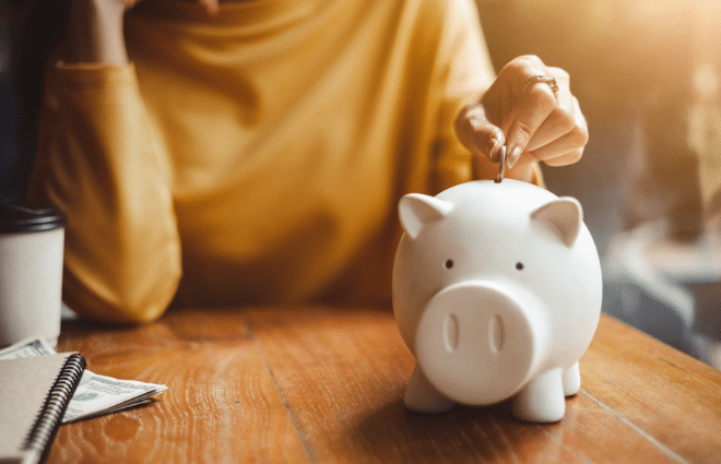 Woman putting money in piggy bank