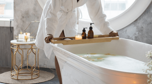 Woman setting up a relaxing bath to help relieve stress