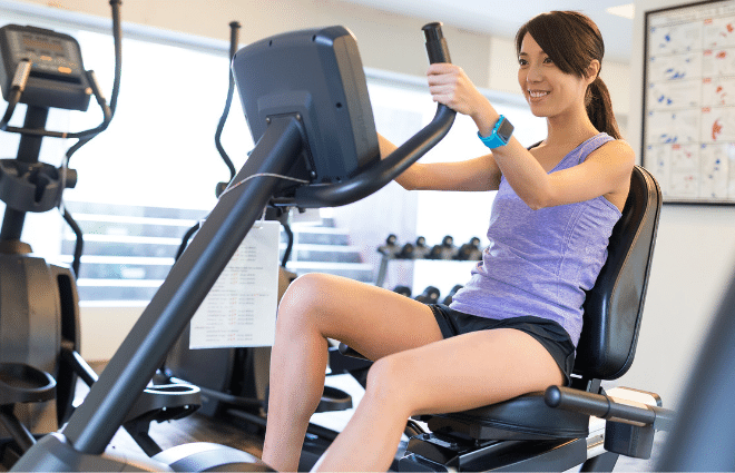 Woman working out on recumbent bike at gym