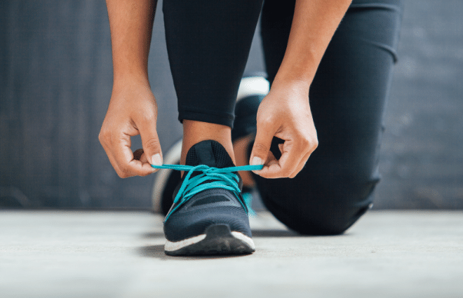 Woman tying laces on running shoes