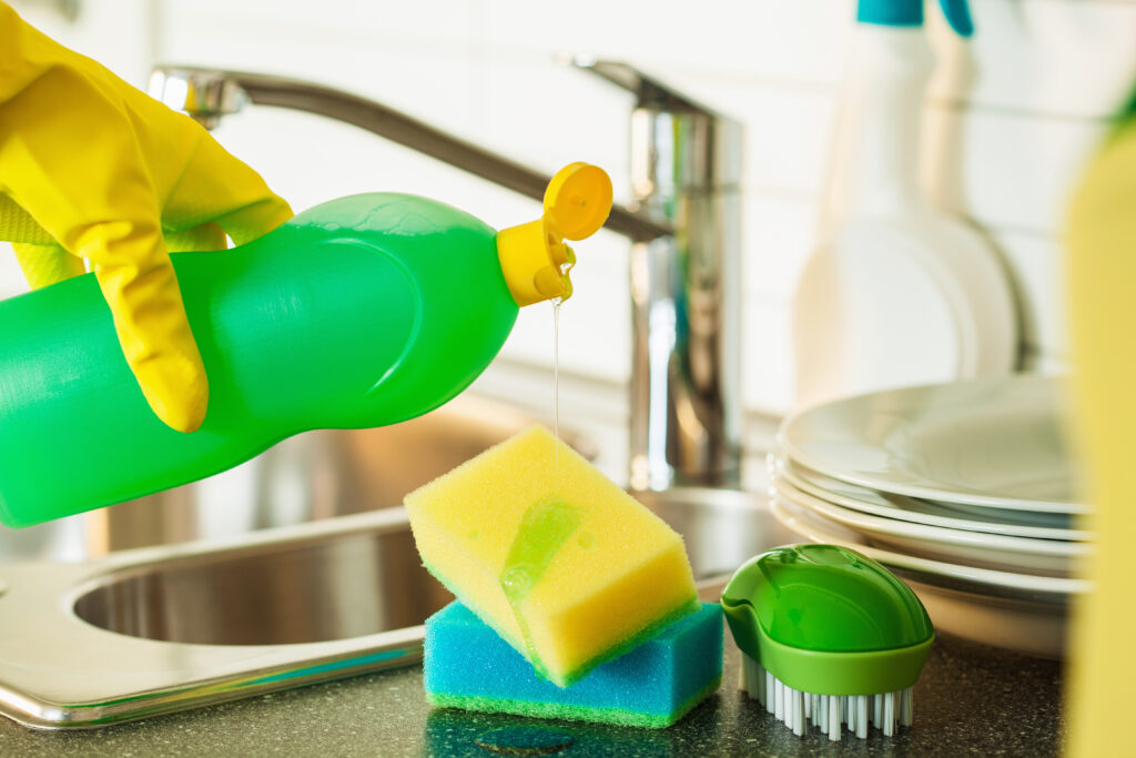 Pouring dishwashing liquid on sponge